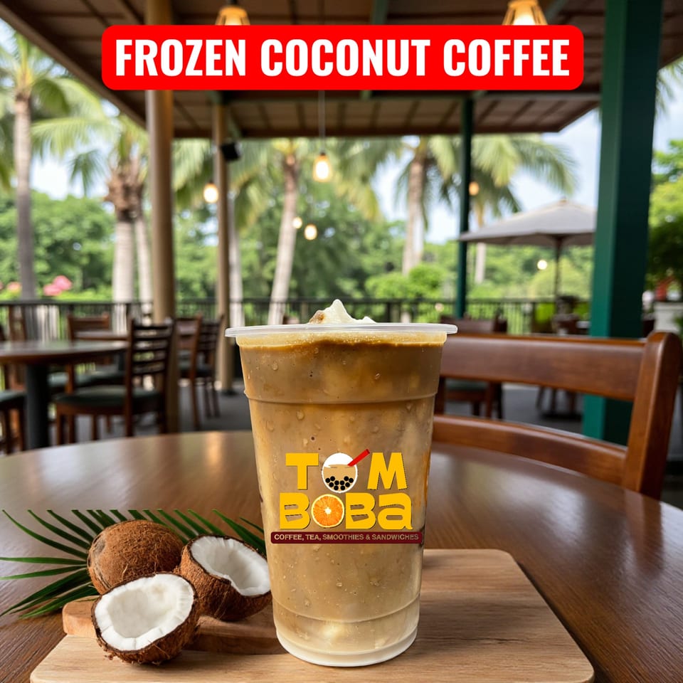 I HEART BOBA FM 529's frozen coconut coffee with whole and halved coconuts on a wooden table.